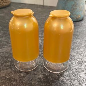 Set of salt and pepper shakers by Tupperware. Gold and clear. NEW without